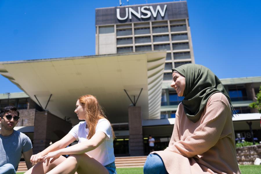 三名新南威尔士大学的学生坐在图书馆外