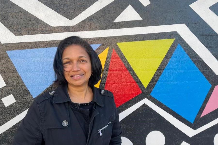 Shamini Chetty在彩色几何形状涂鸦艺术品前的头部照片